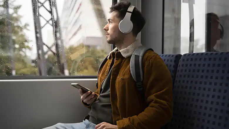 Mobile Unterhaltung unterwegs: Wie man sich auf Reisen die Zeit vertreibt &copy; FreePik | https://www.freepik.com/free-photo/medium-shot-man-wearing-headphones_20081848.htm