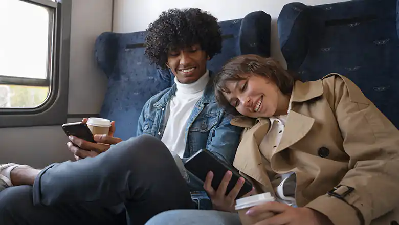 Mobile Unterhaltung unterwegs: Wie man sich auf Reisen die Zeit vertreibt &copy; FreePik | https://www.freepik.com/free-photo/side-view-friends-traveling-by-train_49630144.htm